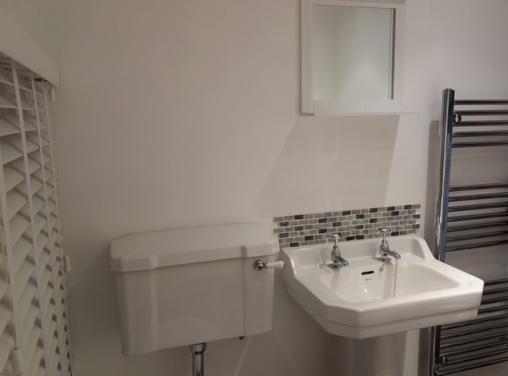 White porcelain WC and sink in bright white painted bathroom